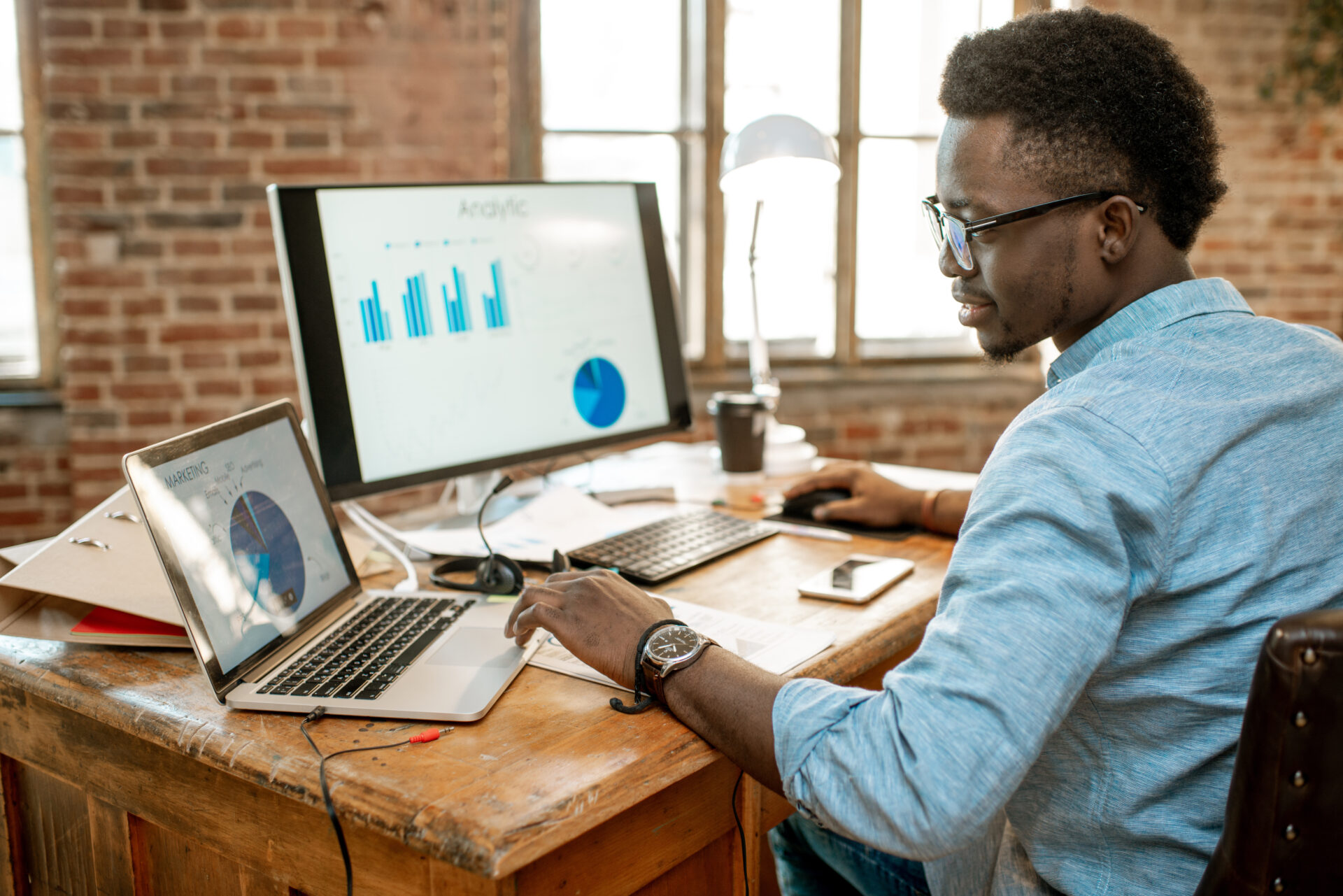 Professional analyzing financial consolidation software dashboard with charts on dual monitors