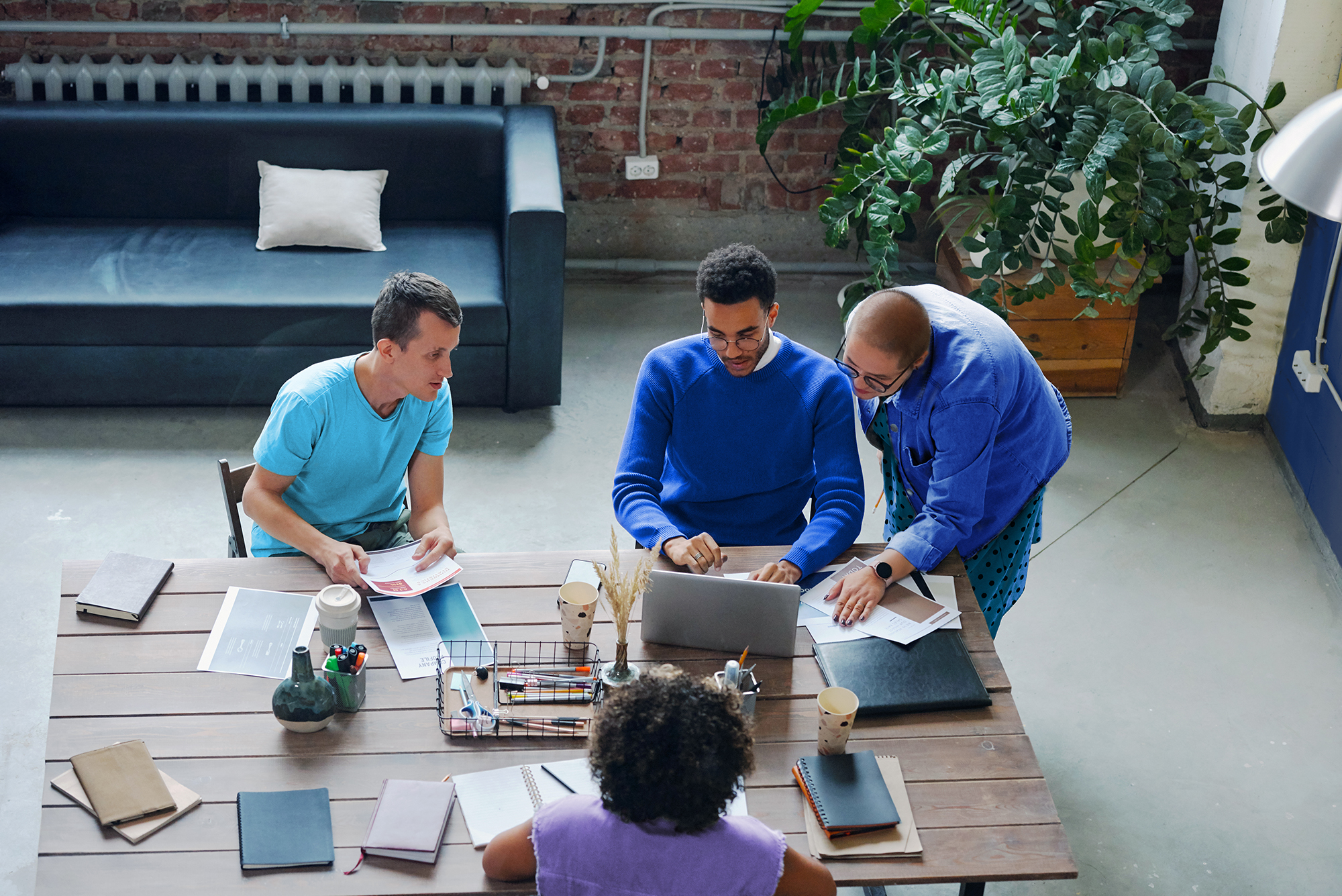 Team collaborating around laptop on AI-driven financial close management workflow and reporting