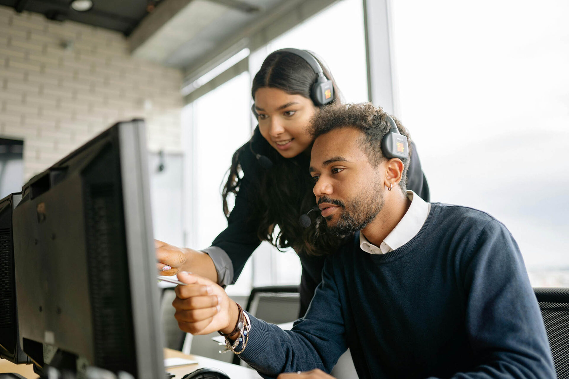 Technology leaders collaborating on financial close management tasks using software at computer