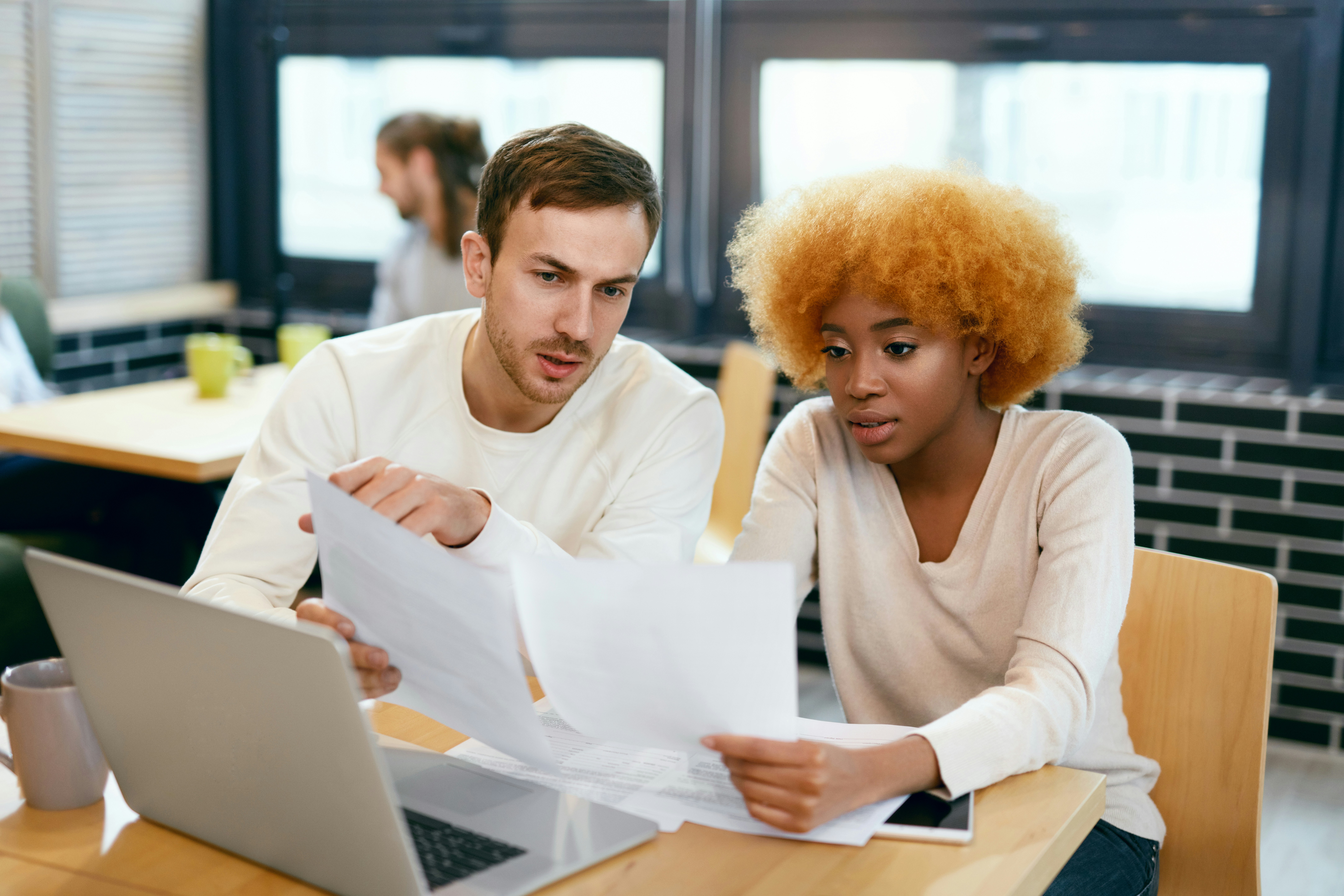 Male and female coworkers conducting general ledger reconciliation