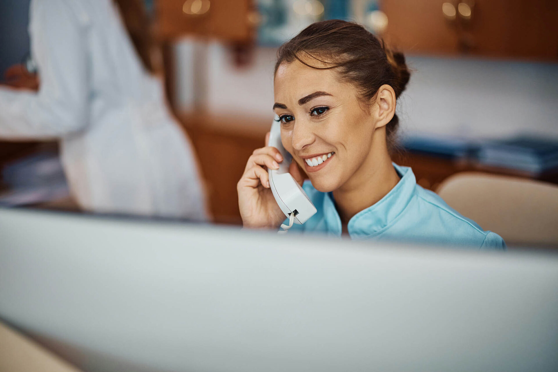 Insurance professional providing audit and compliance support while on phone at office desk