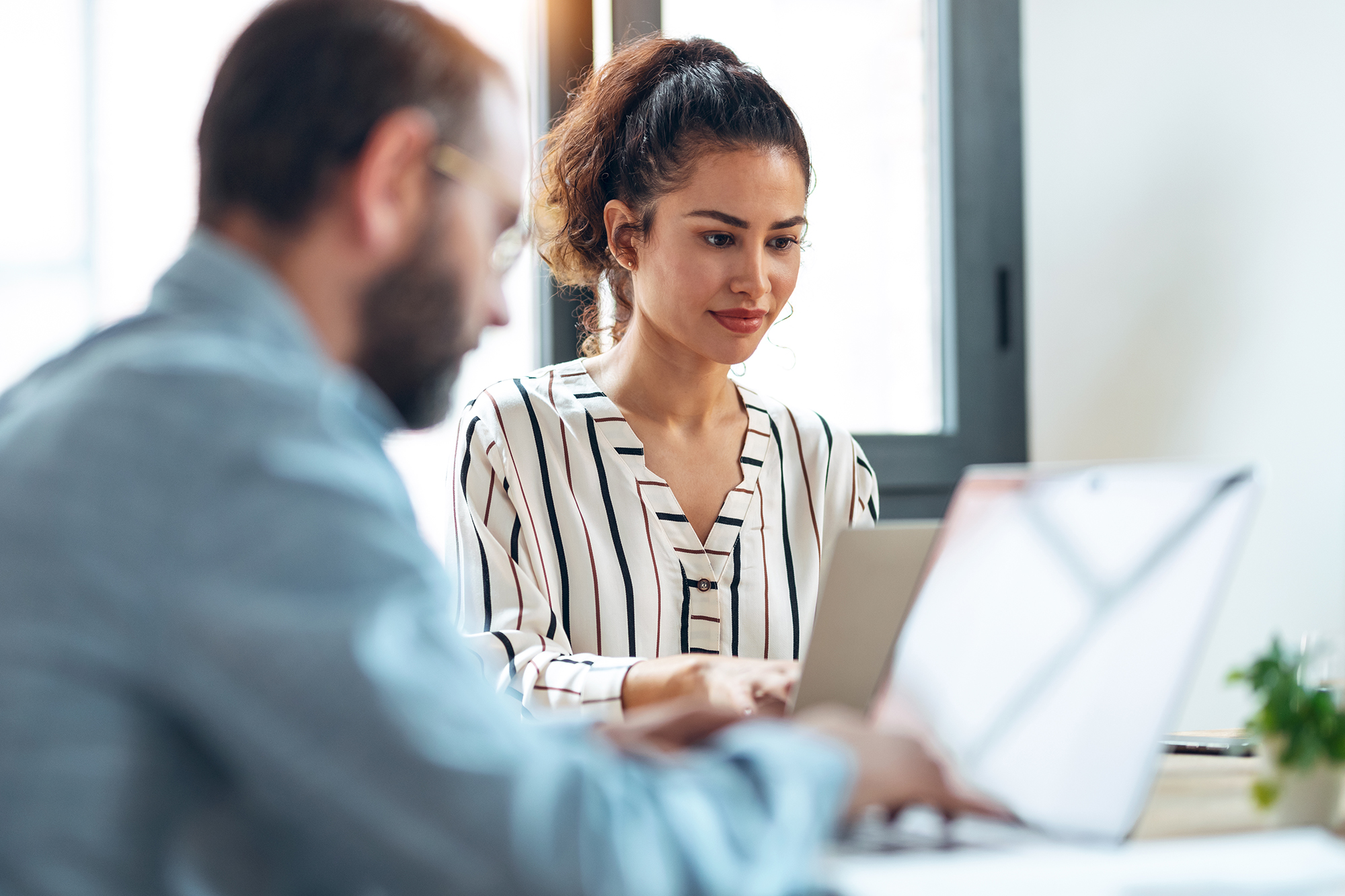 Professional reviewing reports on laptop using Workday ERP financial reporting integration with Trintech